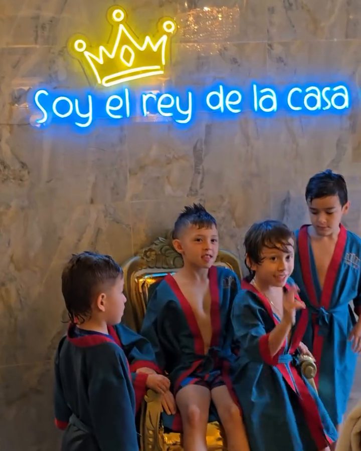 Niños en bata junto a la silla dorada y el letrero "Soy el rey de la casa"